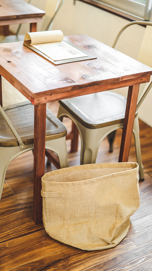 完全無料の大人おしゃれな待ち受け・スマホ壁紙：テーブルにメニュー、床に荷物入れがあるカフェの店内