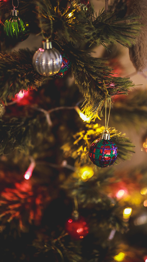 TikTok/YouTubeショートの背景にも使えるおしゃれな画像：クリスマスツリーに飾られたカラフルなオーナメントとイルミネーションのきらめき