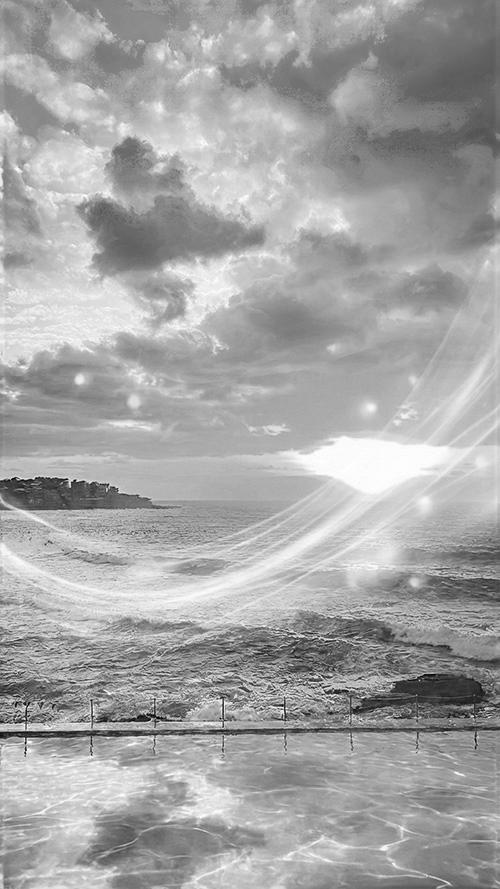 無料のおしゃれな縦長画像：黄金色の夕日が差し込む海辺のインフィニティプールと神秘的な光（白黒版）