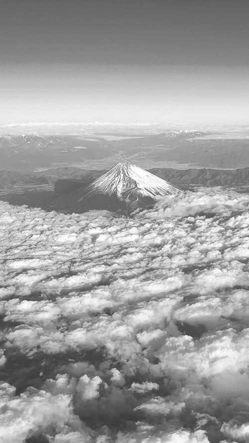 無料のおしゃれな縦長画像：一面の雲海の上に頭を出す雪化粧した富士山の絶景（白黒版）